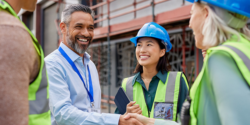 Man shaking hands with construction professionals using ProjectTeam.com